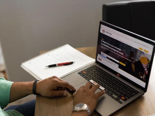 hands on a laptop computer with screen showing the ASU site